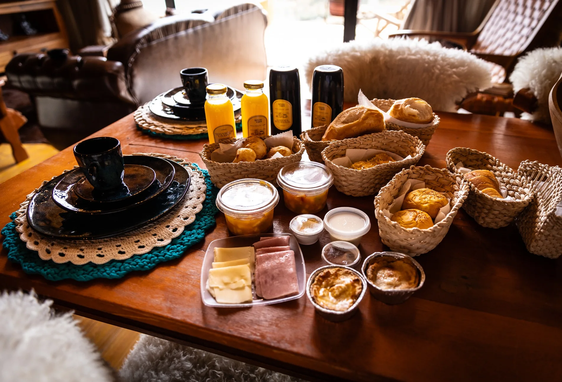 Café da manhã na cabana com pães em cestas, frutas, queijos e bebidas